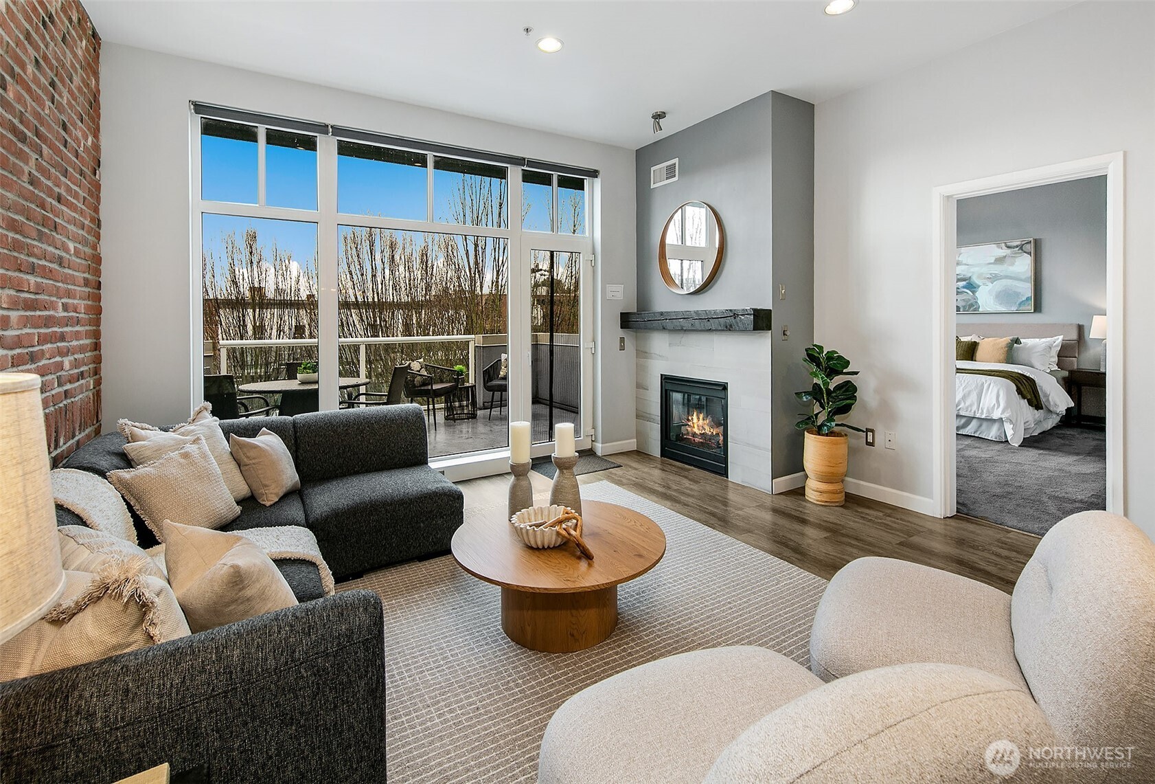 a living room with furniture a fireplace and a large window