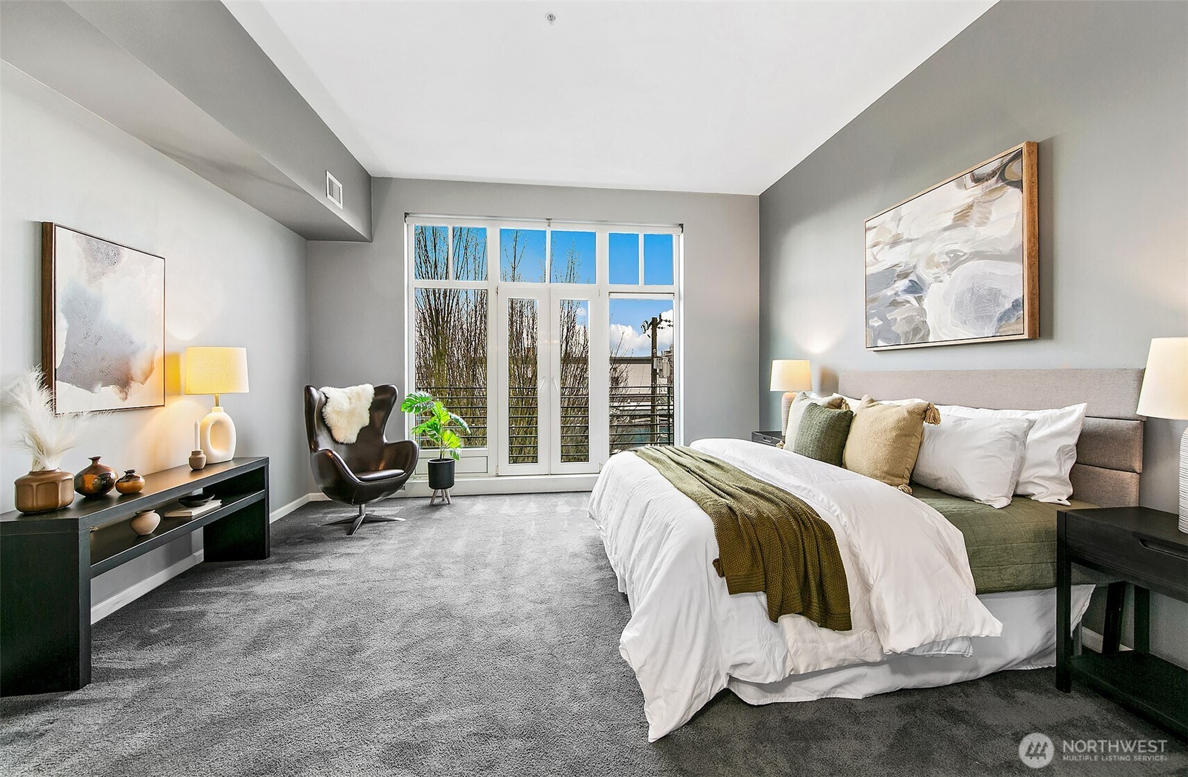 17 West Mercer Street, Unit 302 Seattle, WA 98119 - Photo 12 of 28 a spacious bedroom with a bed a couch and a window