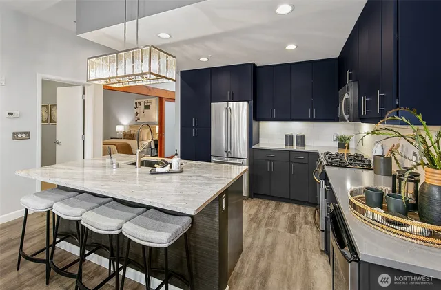 a kitchen with granite countertop a table chairs stove and refrigerator
