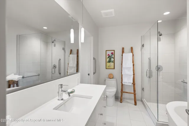 a bathroom with a double vanity sink mirror and shower
