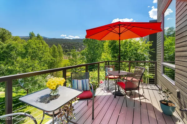 a view of a balcony with furniture and wooden floor