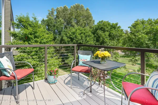 a balcony with wooden floor table and chairs