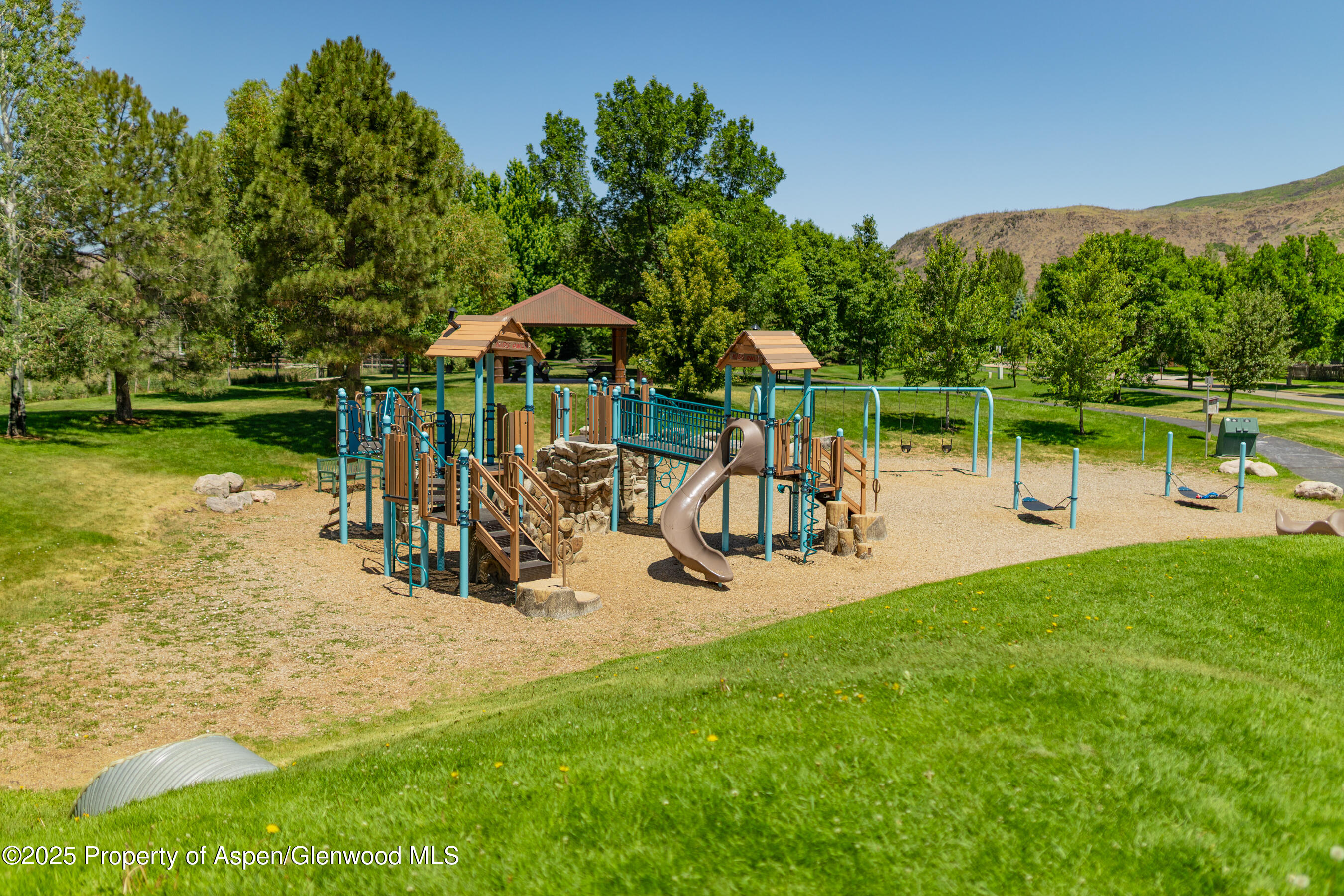 202 Evans Road, Unit 202 Basalt, CO 81621 - Photo 29 of 29 a view of a lake with a table and chairs under an umbrella