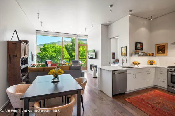 a kitchen with a table chairs refrigerator and cabinets