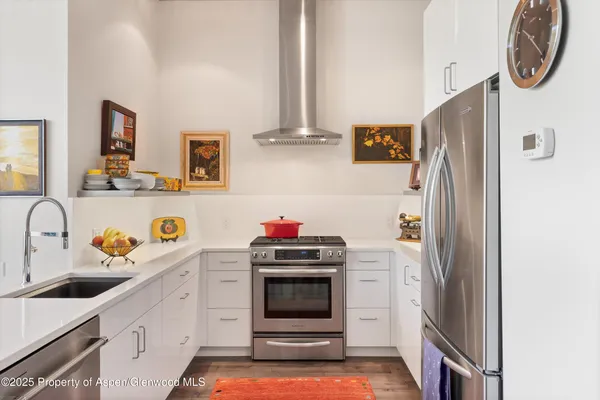 a kitchen with kitchen island a sink a stove and refrigerator