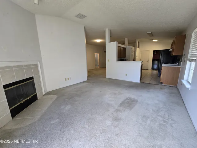 a view of a kitchen with a sink and an empty room
