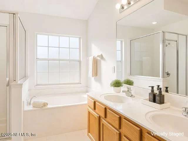 a bathroom with a granite countertop sink a bathtub and a mirror
