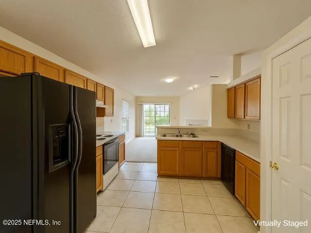 a large kitchen with a refrigerator and a sink