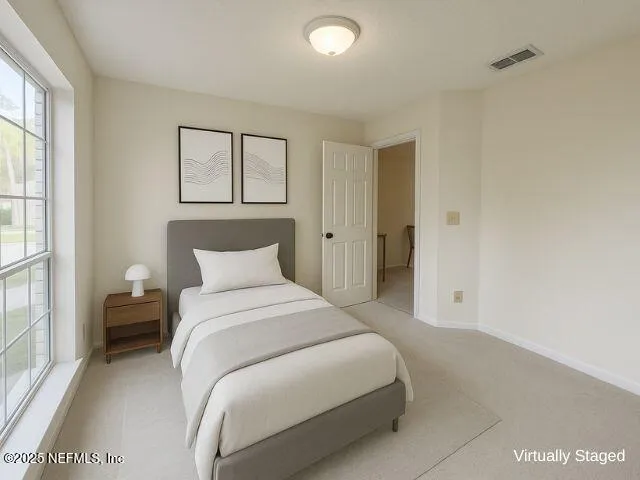 a bedroom with a bed and a painting on the wall