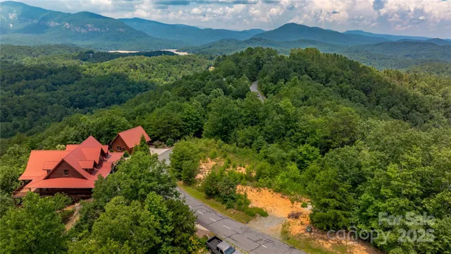 an aerial view of house with yard and mountain view in back