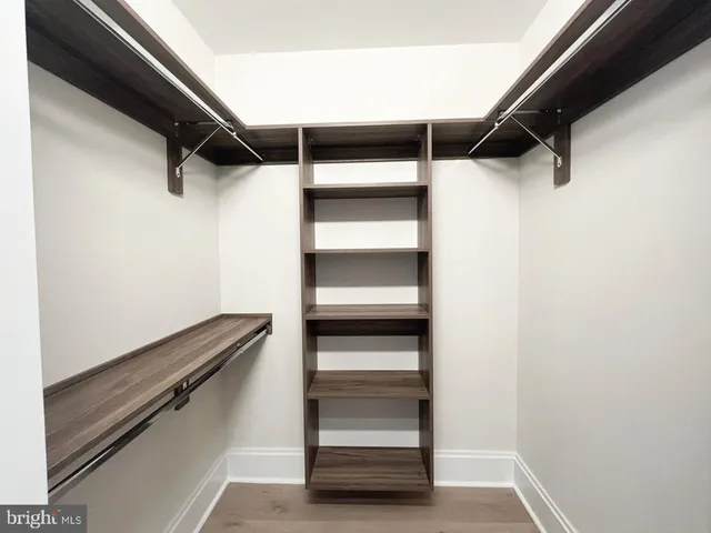 a view of walk in closet with empty racks