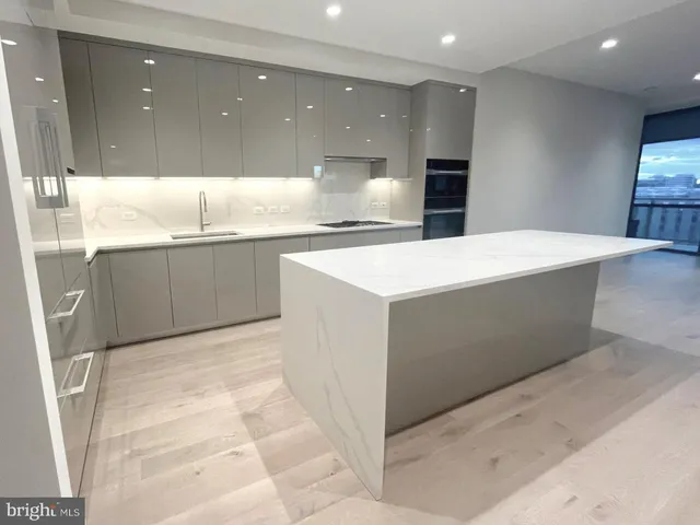 a large kitchen with kitchen island a sink a counter top and stainless steel appliances