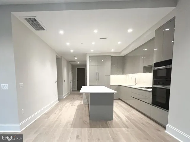 a large kitchen with a sink and stainless steel appliances