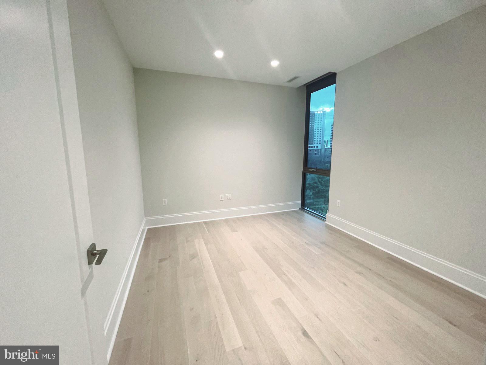 7887 Jones Branch Drive, Unit 1104 McLean, VA 22102 - Photo 6 of 42 an empty room with wooden floor and windows