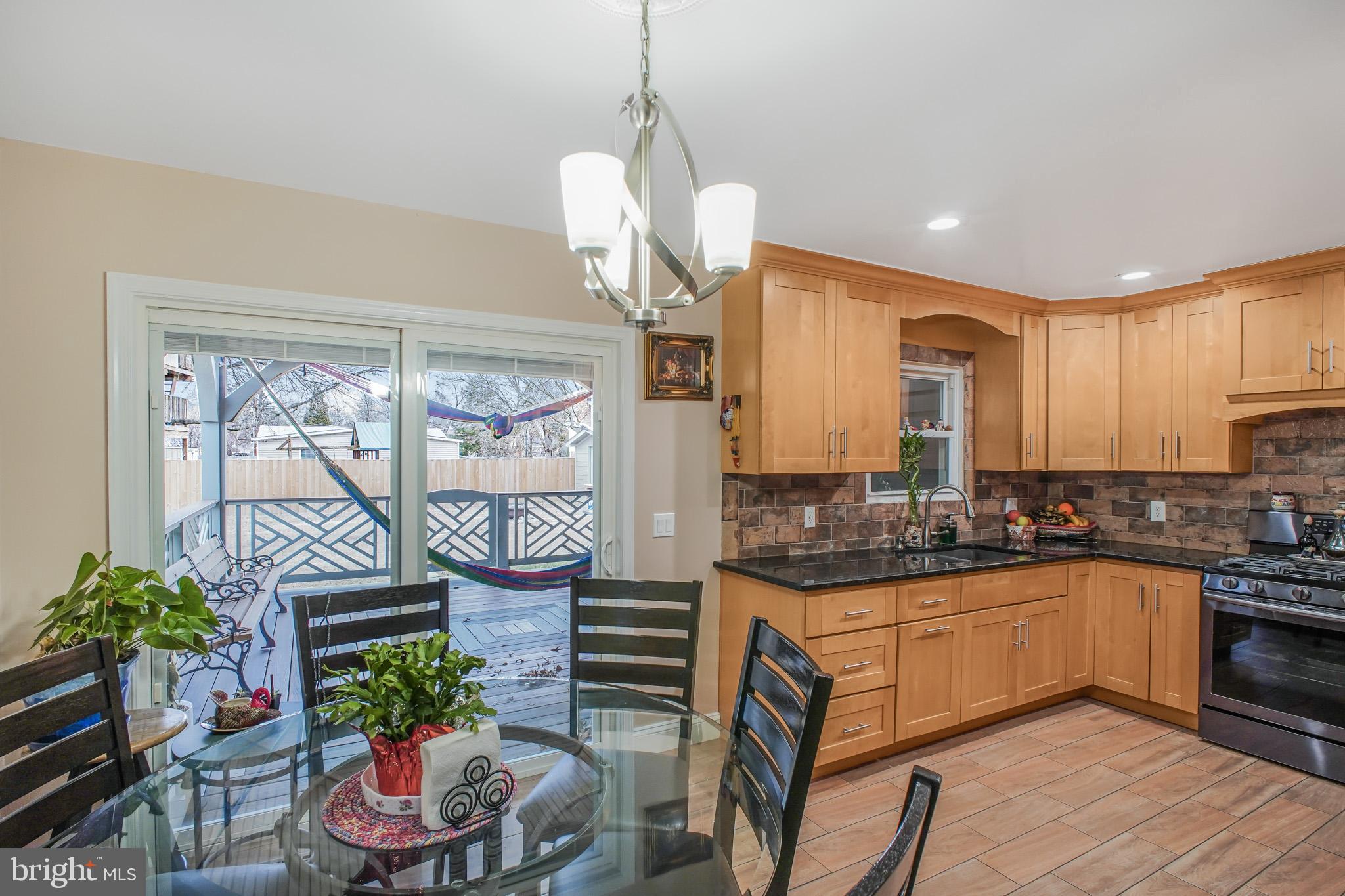 8227 Frye Road Alexandria, VA 22309 - Photo 6 of 45 a kitchen with granite countertop a stove a sink a refrigerator dining table and chairs