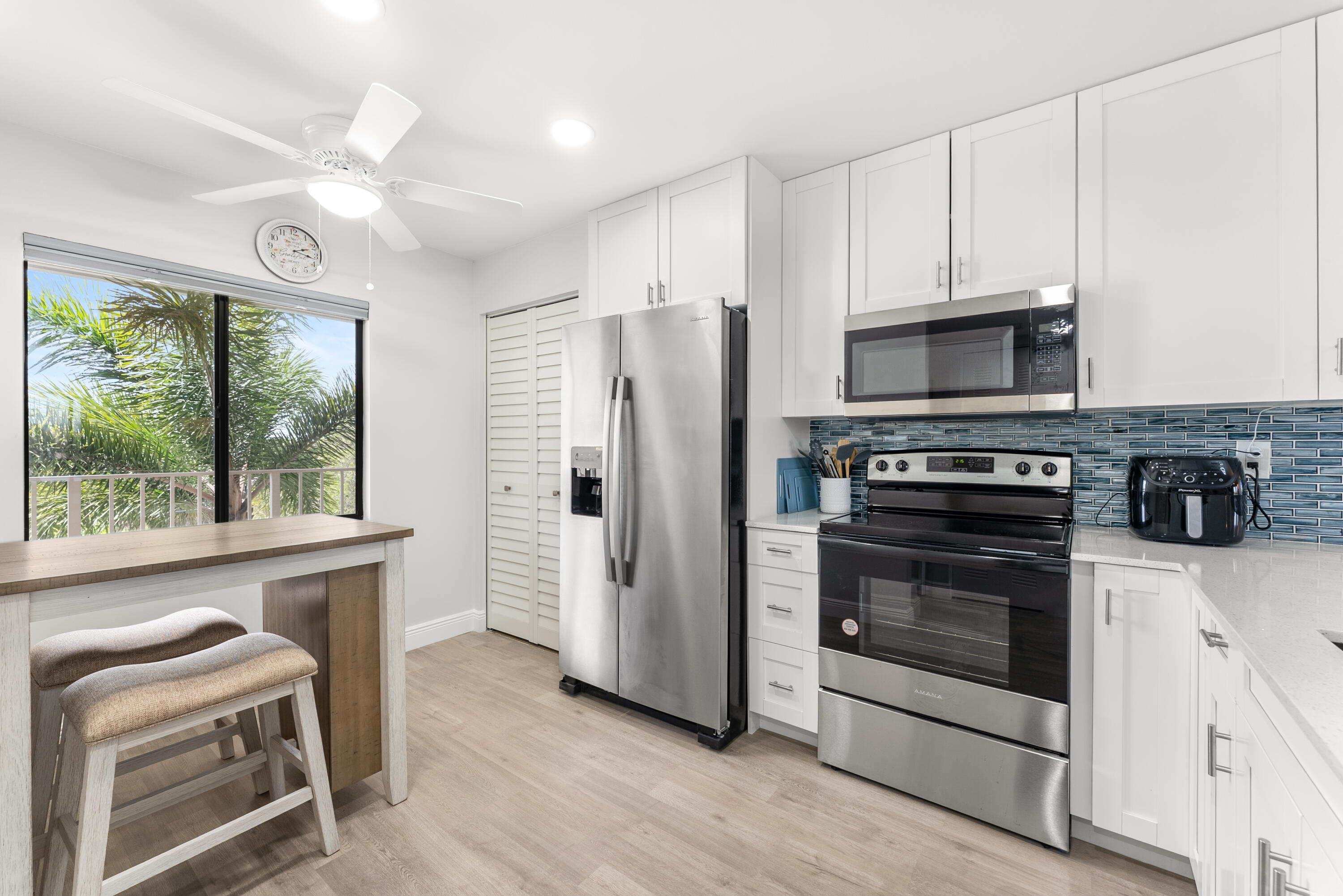 14500 Stirling Way, Unit 403 Delray Beach, FL 33446 - Photo 5 of 47 a kitchen with stainless steel appliances a stove a refrigerator and a microwave
