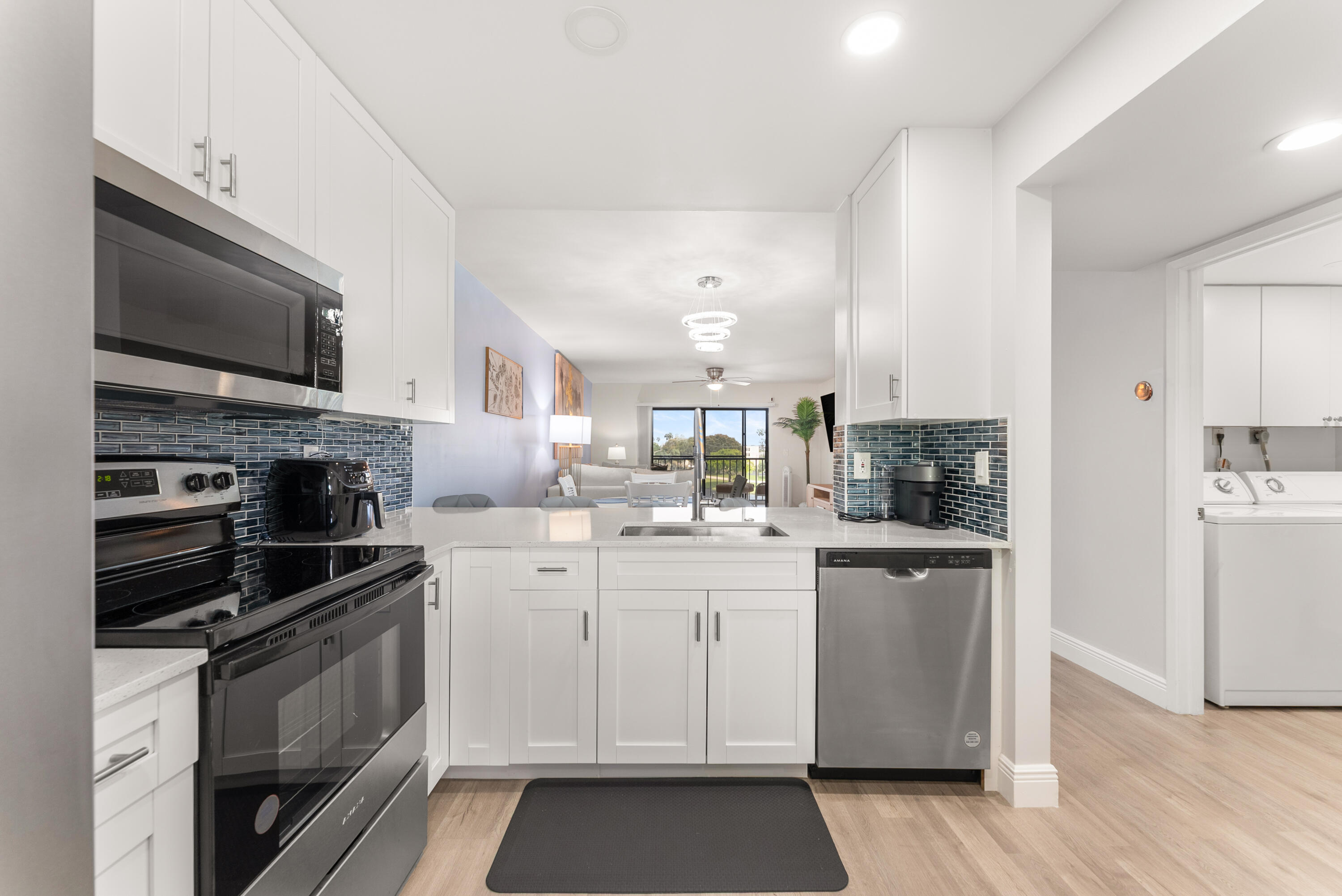 14500 Stirling Way, Unit 403 Delray Beach, FL 33446 - Photo 7 of 47 a kitchen with a sink stainless steel appliances and cabinets