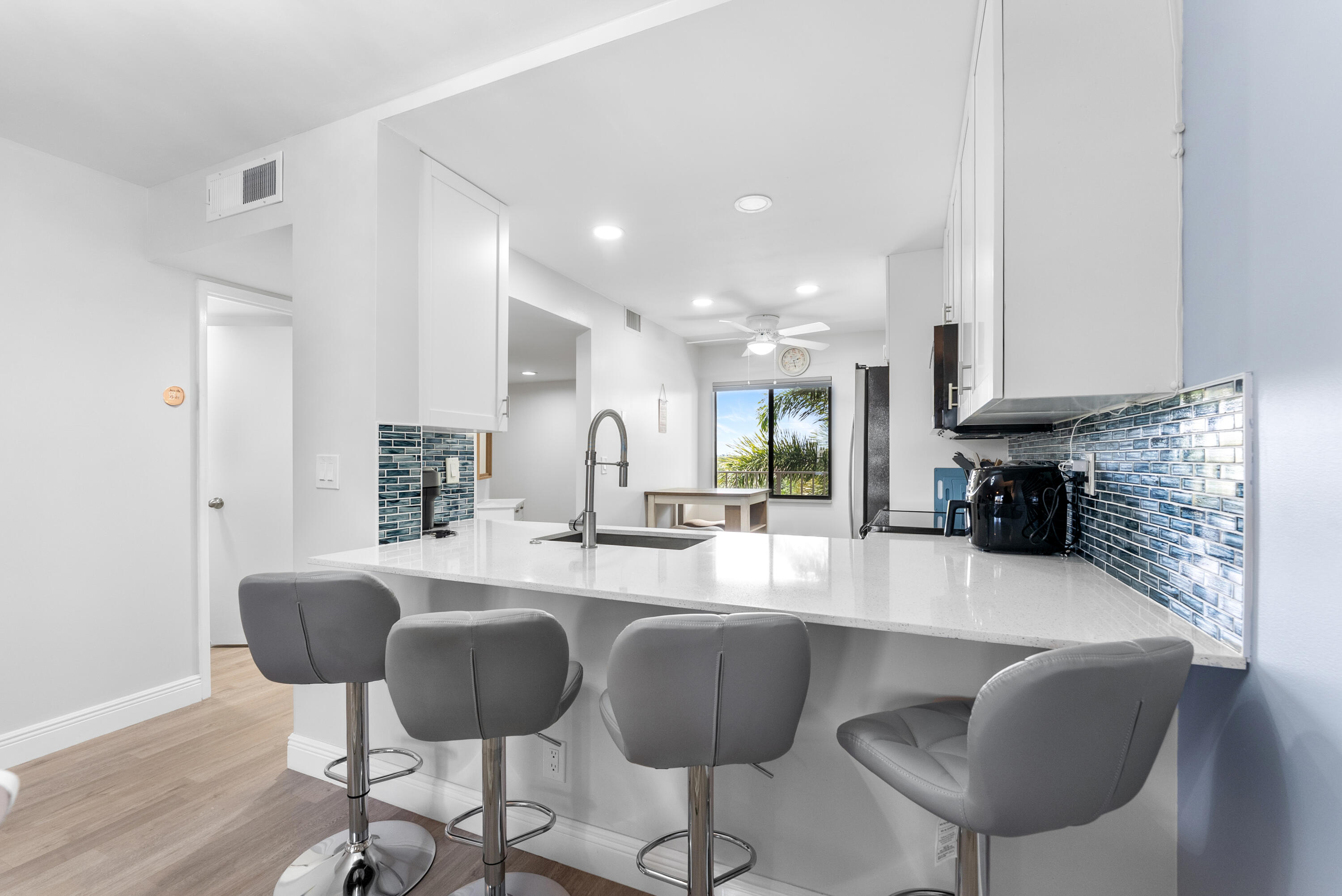 14500 Stirling Way, Unit 403 Delray Beach, FL 33446 - Photo 8 of 47 a kitchen with cabinets a sink and chairs