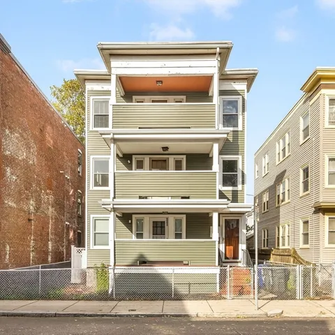 a front view of a building with a garden