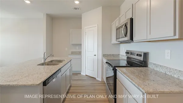 a kitchen with stainless steel appliances granite countertop a sink stove and cabinets