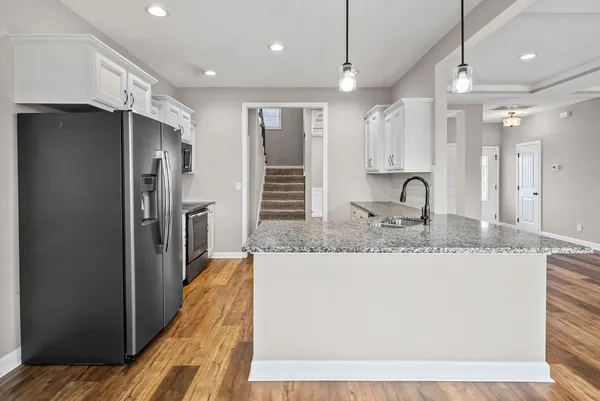 a kitchen with kitchen island a counter top space a sink stainless steel appliances and cabinets