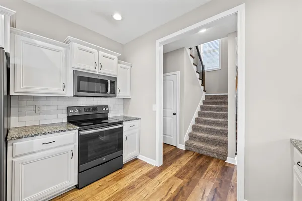 a kitchen with wooden floor and white appliances