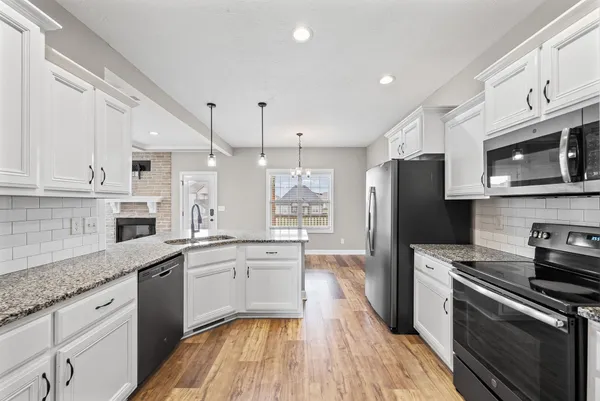 a kitchen with stainless steel appliances granite countertop a sink stove and refrigerator
