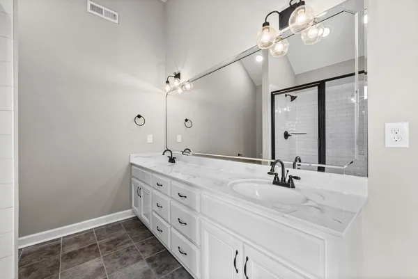 a bathroom with a double vanity sink and a mirror
