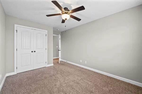 an empty room with chandelier fan