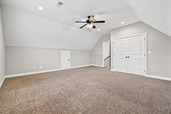 an empty room with windows and ceiling fan