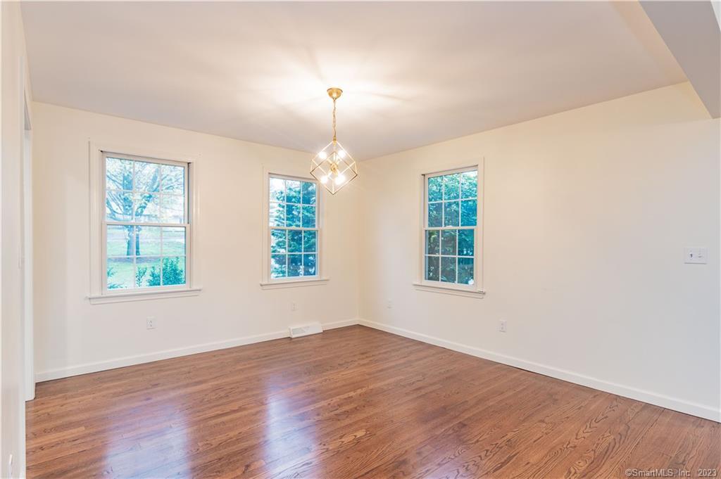 1241 Halladay Avenue West Suffield, CT 06078 - Photo 9 of 29 an empty room with wooden floor exposed radiator and windows