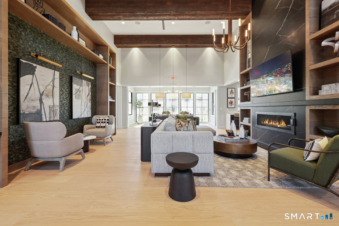3 Edgewood Way, Unit 26 Woodbridge, CT 06525 - Photo 4 of 7 Club House main meeting room with linear fireplace, TV, kitchen off to the right, and dining table with additional seating.