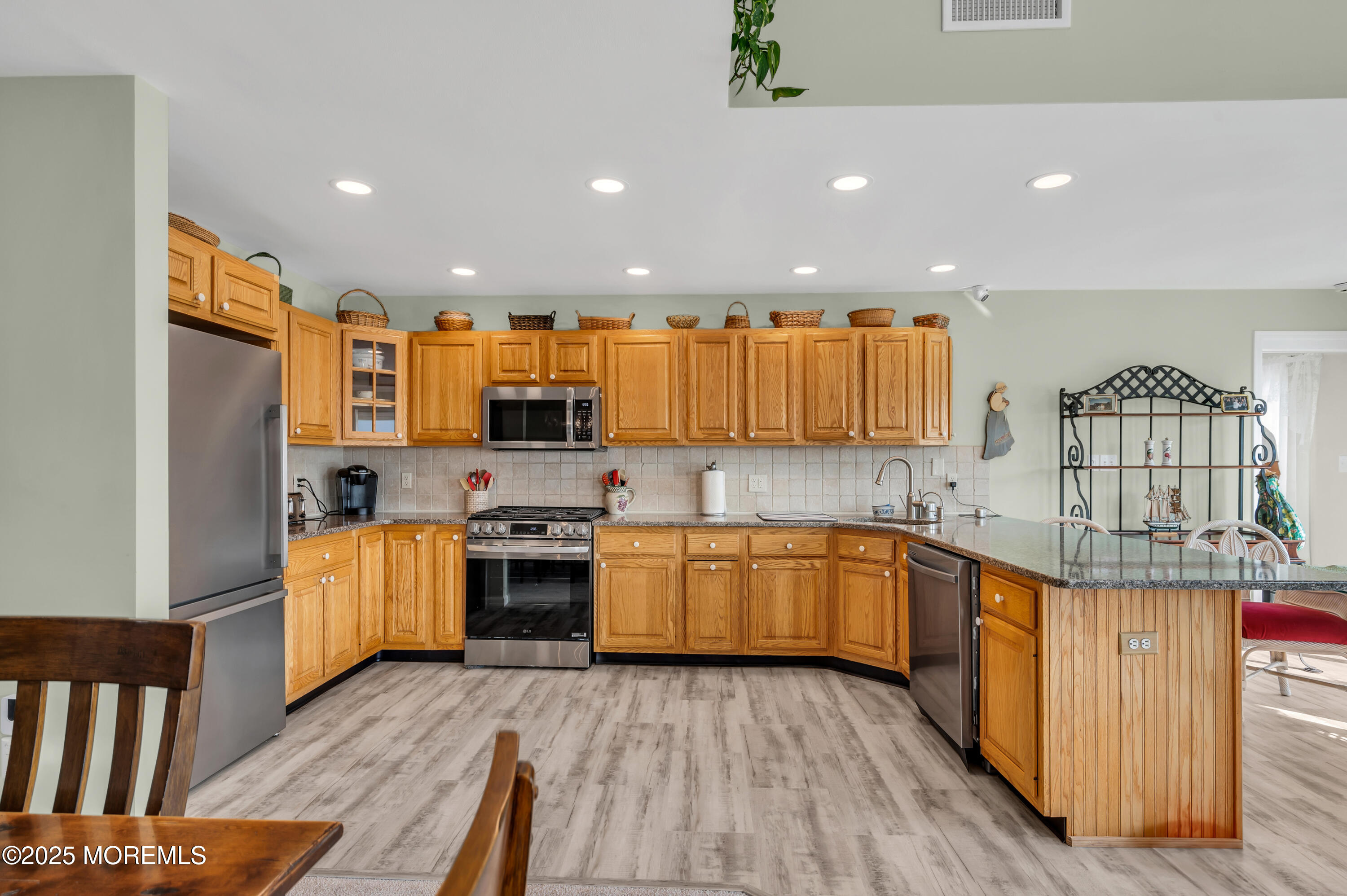 837 Forepeak Drive Forked River, NJ 08731 - Photo 38 of 55 a kitchen with stainless steel appliances granite countertop a stove top oven a sink dishwasher and a refrigerator with wooden floor