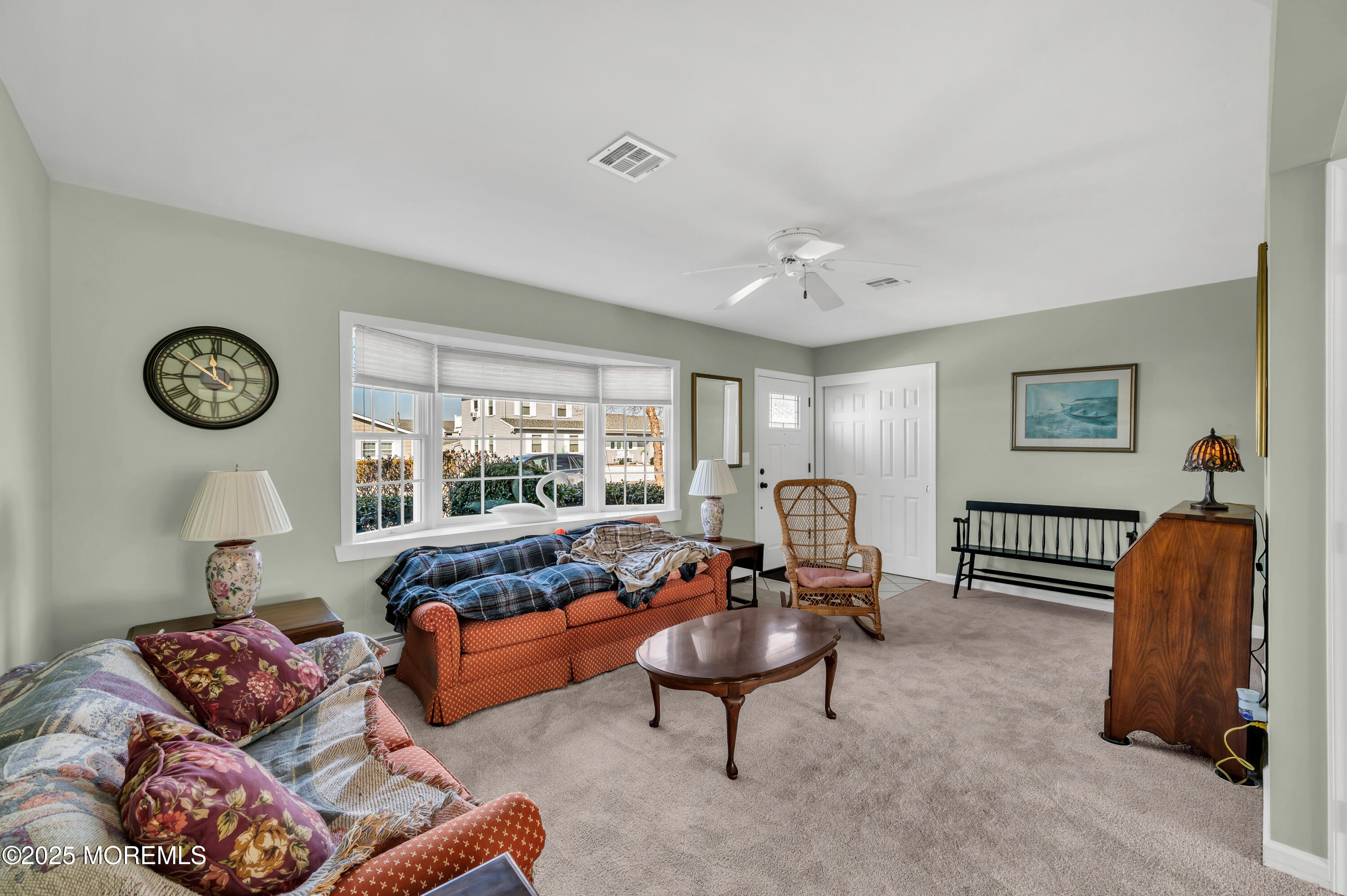 837 Forepeak Drive Forked River, NJ 08731 - Photo 47 of 55 a living room with furniture a clock on the wall and a window