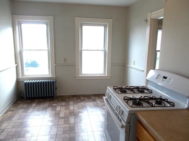 a kitchen with a stove a sink and a window