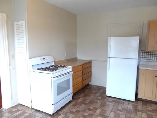 a kitchen with a stove top oven and refrigerator