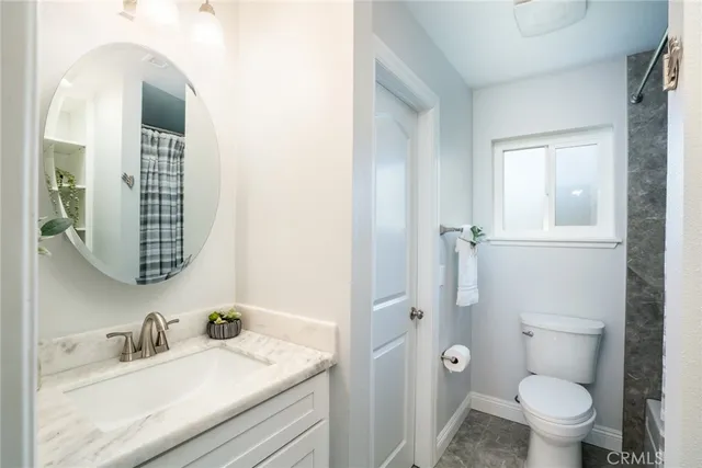 a bathroom with a granite countertop sink toilet and shower