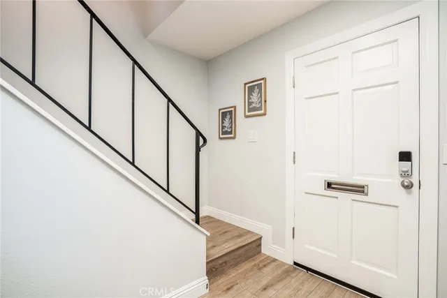 a view of hallway with stairs and wooden floor