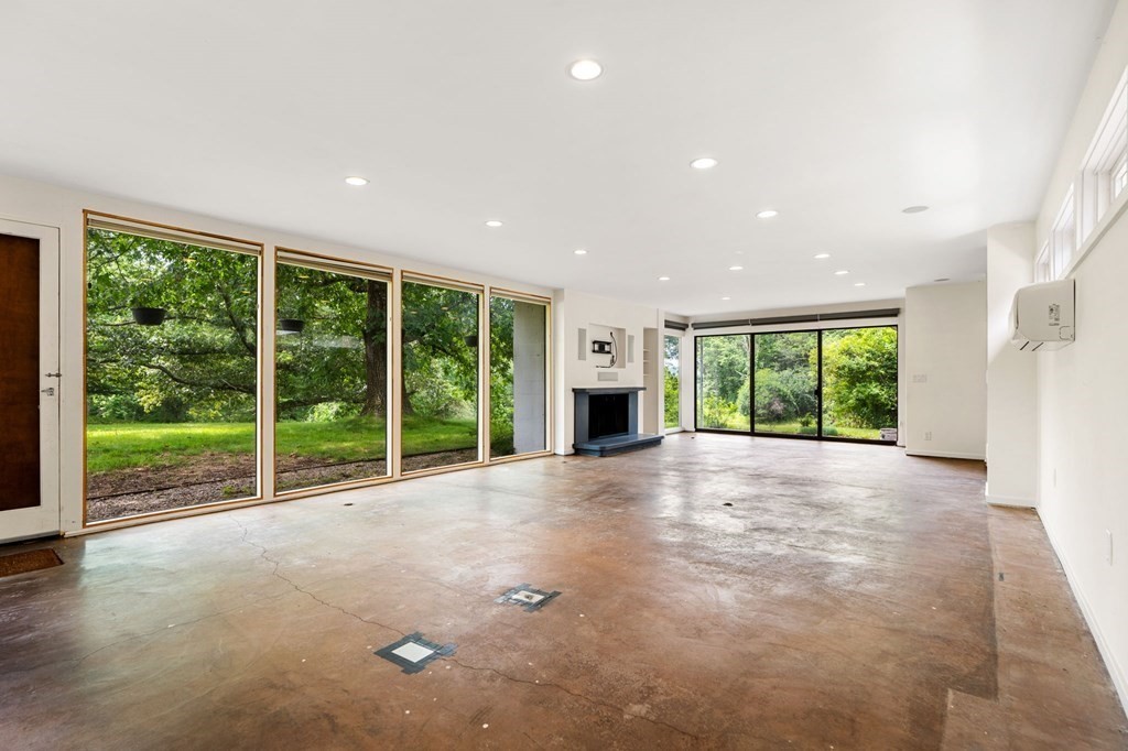91 Weston Road Lincoln, MA 01773 - Photo 17 of 34 a view of an empty room with a fireplace and a large window