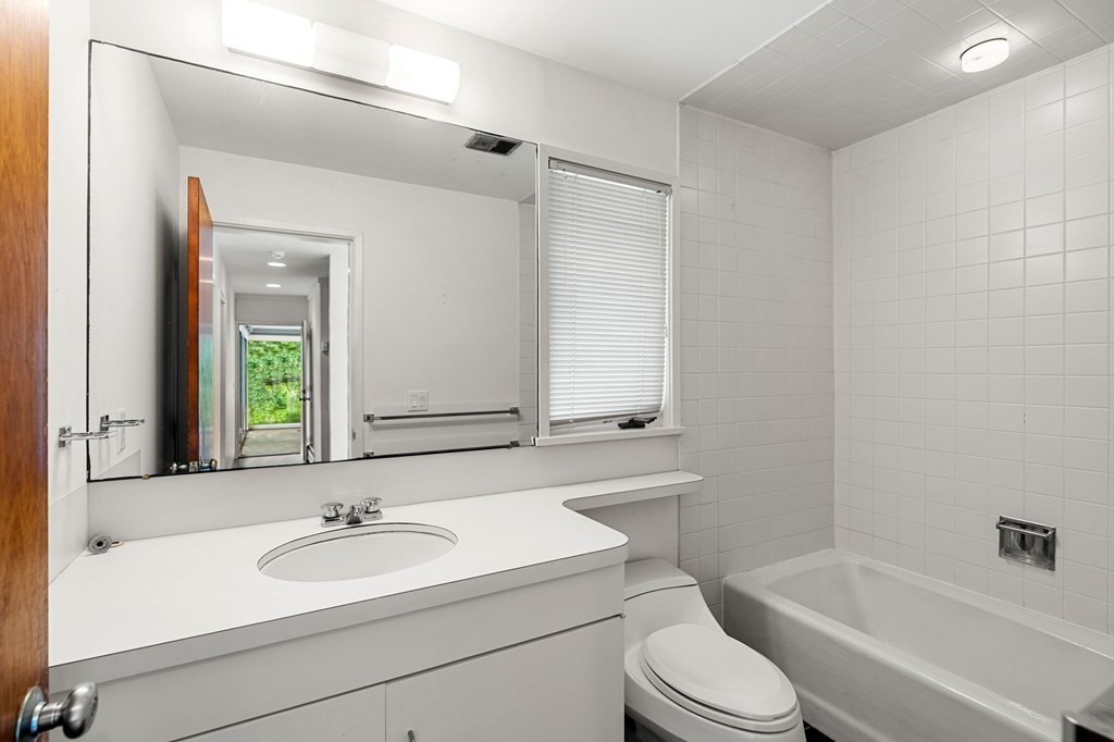 91 Weston Road Lincoln, MA 01773 - Photo 23 of 34 a bathroom with a sink toilet a mirror and bathtub