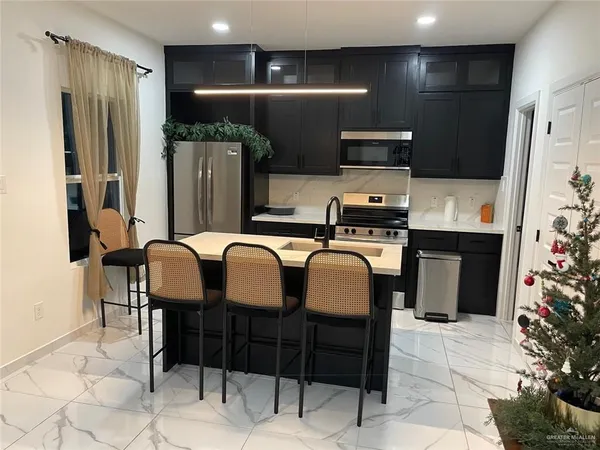 a kitchen with stainless steel appliances granite countertop a refrigerator and a stove top oven