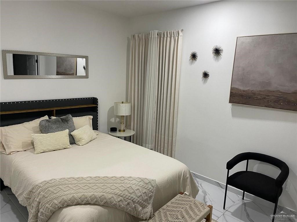 607 Buccaneer Drive, Unit 4 Hidalgo, TX 78557 - Photo 8 of 9 a bedroom with a bed and chair
