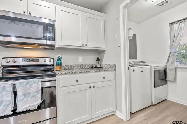 a kitchen with white cabinets and white appliances