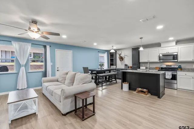 a living room with furniture and kitchen view