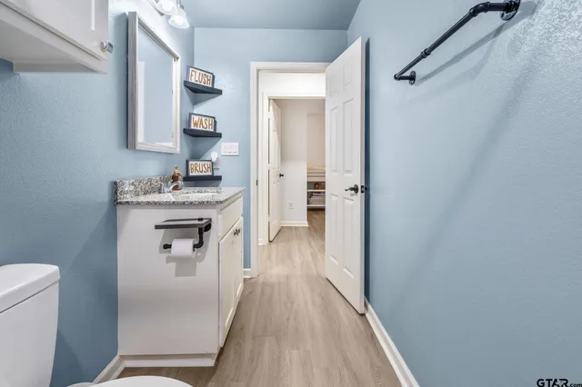 a kitchen with a refrigerator a sink and wooden floor