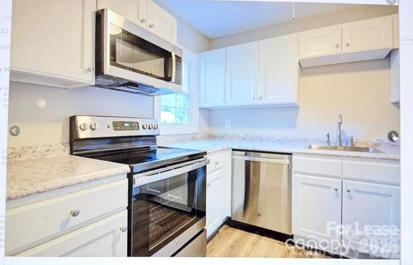 a kitchen with stainless steel appliances granite countertop a stove microwave and cabinets