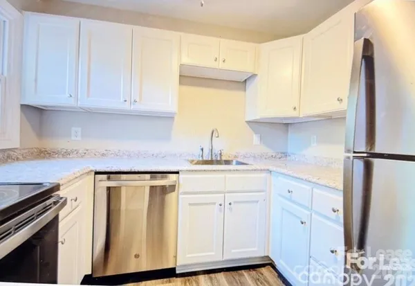 a kitchen with white cabinets and a refrigerator