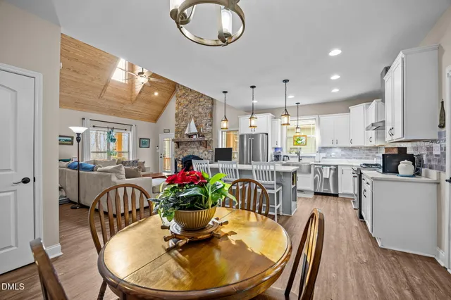 a view of a dining room and livingroom with furniture wooden floor and a chandelier