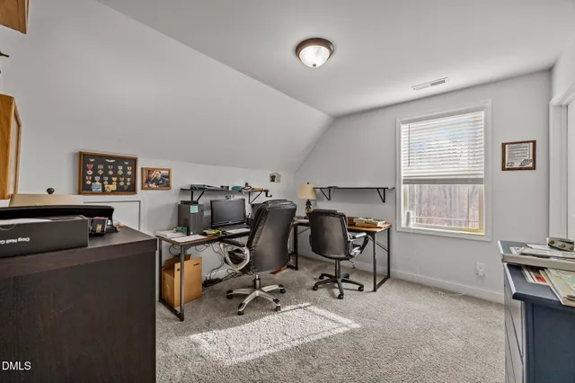 a view of a workspace with furniture and a window