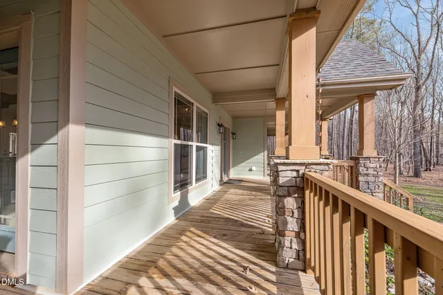 a view of a balcony with wooden floor and fence